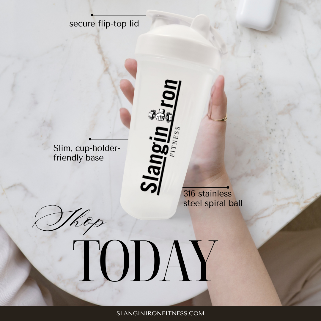 Hand holding a white protein shaker cup with 'Slangin Iron Fitness' branding on a marble surface.